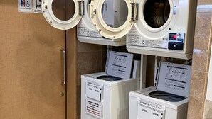 A laundry facility with three stacked dryers and a door with handrails. - Toyoko Inn Kobe Sannomiya-eki Higashi (Kobe)