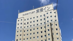 Een hotelgebouw met meerdere verdiepingen, met een bord in Japanse karakters.