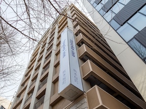 A multi-story building with a modern architectural design, featuring balconies and large windows. - Toyoko Inn Kumamoto Sakuramachi Bus Terminal Mae (Kumamoto)