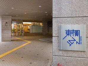Entrada de un edificio con un letrero que dice 'Toyoko Inn'.