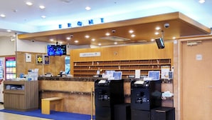 A reception desk with a wooden counter, a clock, and a sign indicating a private area. There are multiple ATMs and a blue carpeted area. - Toyoko Inn Tokyo Shinjuku Kabukicho (Tokyo)