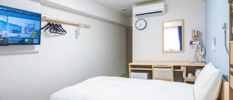 A hotel room with two beds, a desk, a clock, a mirror, a TV, and a window.