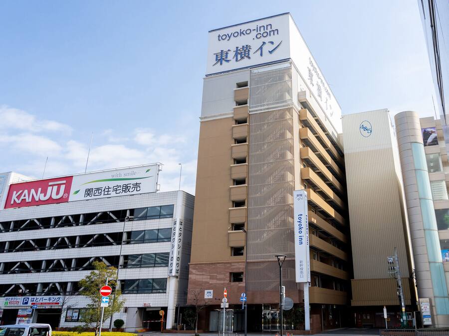 A multi-story building with a prominent sign for Toyoko Inn and a Kanju store.
