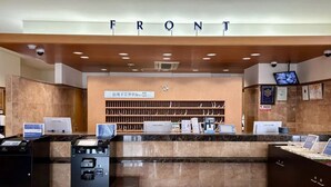 A reception desk with a 'FRONT' sign above, a computer, a cash register, and a small refrigerator.