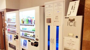 A row of vending machines and an ice dispenser in a hallway.