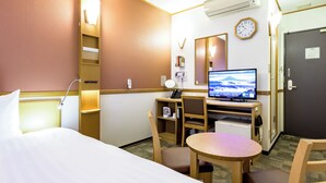 A hotel room with a bed, desk, chair, and a television.