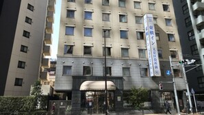 A multi-story hotel with a uniform facade, large windows, and a central entrance with a canopy. - Toyoko Inn Tokyo Korakuen Bunkyokuyakusho Mae (Tokyo)