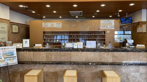 A hotel reception area with a marble counter, wooden benches, and a sign that reads "FRONT". - Toyoko Inn Hitachi Ekimae (Hitachi)