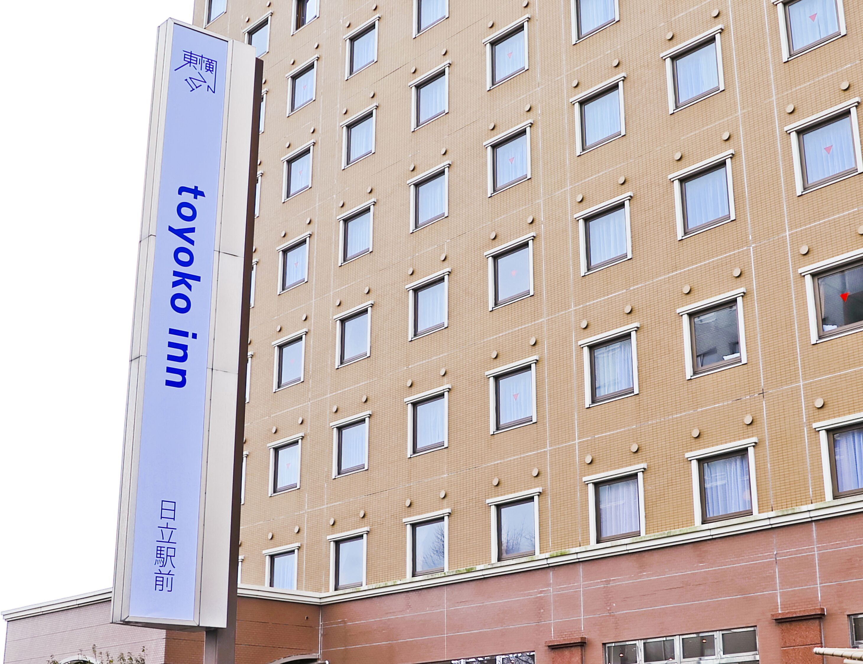 A tall building with a sign for 'Toyoko Inn' and Japanese characters.