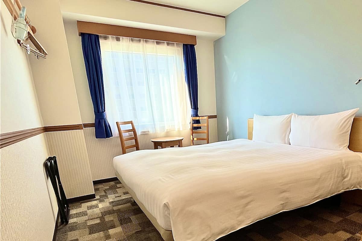 Ein Hotelzimmer mit einem Bett, einem Schreibtisch und einem Stuhl.