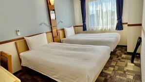 Habitación de hotel con dos camas, una ventana con cortinas, una mesita de noche y un espejo.