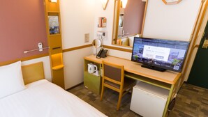 A hotel room with a bed, a desk with a computer, a mirror, a clock, and a small refrigerator. - Toyoko Inn Kawasaki Ekimae Isago (Kawasaki)