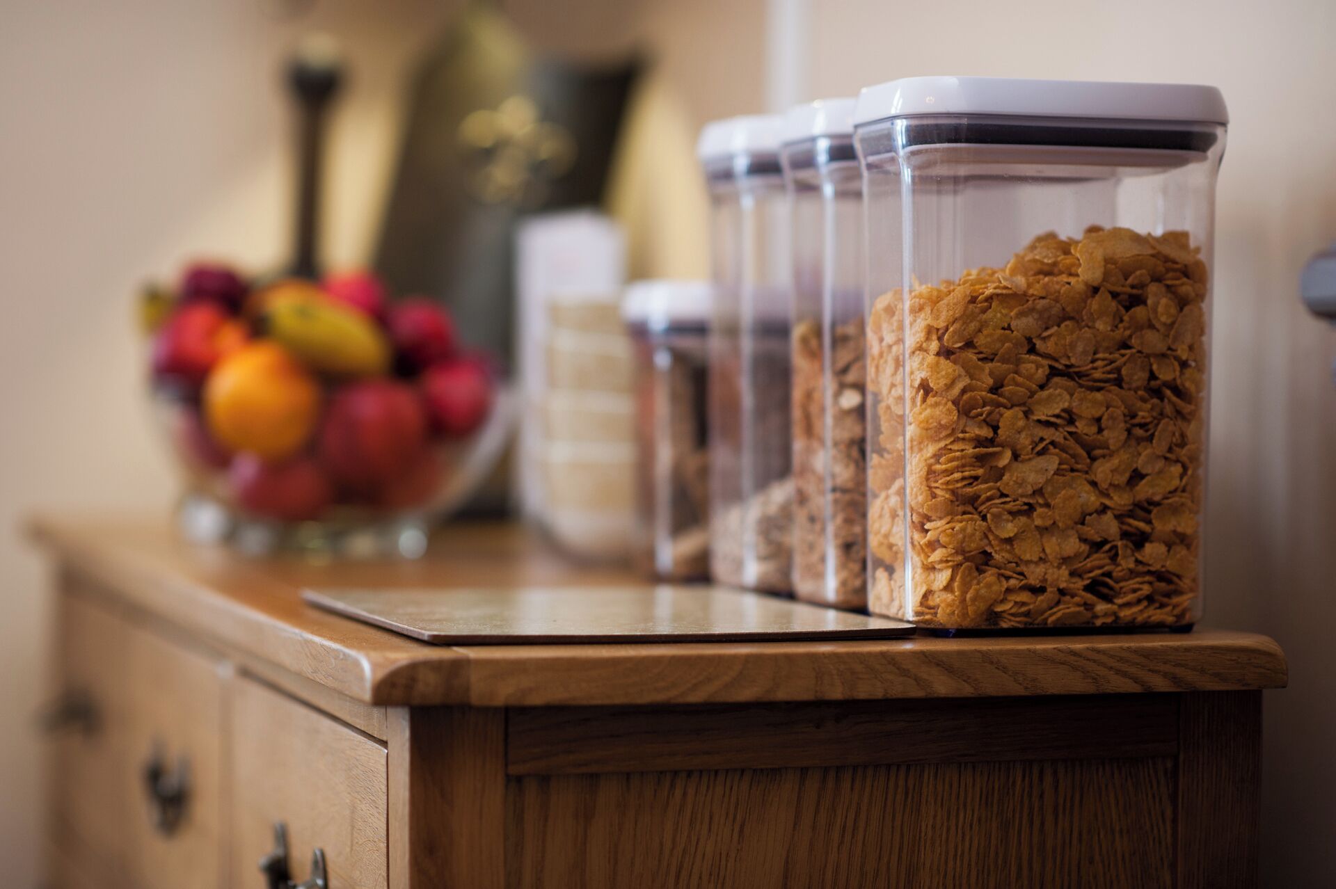 A kitchen counter with clear containers holding various food items.