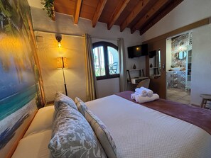 A hotel room with a bed, a lamp, a TV, and a view of the outside. - Hotel Altea Paradise 1917 (Altea)