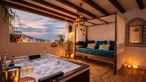 Un dormitorio acogedor con una cama grande, dosel y una bañera con hielo, además de un balcón con vistas.