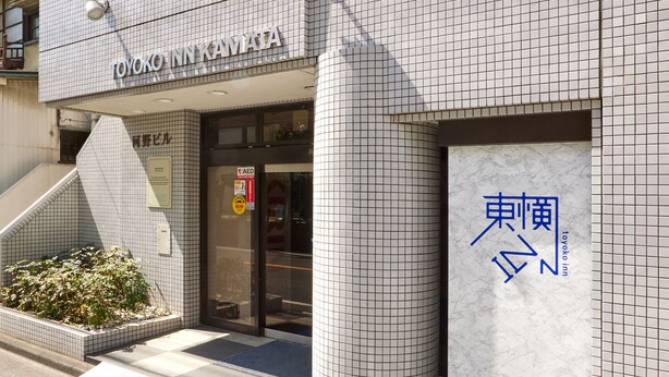 A building with a tiled facade and a sign reading "TOYOKO INN".