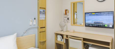 A hotel room with a bed, a desk, a mirror, a clock, and a TV displaying a scenic view.