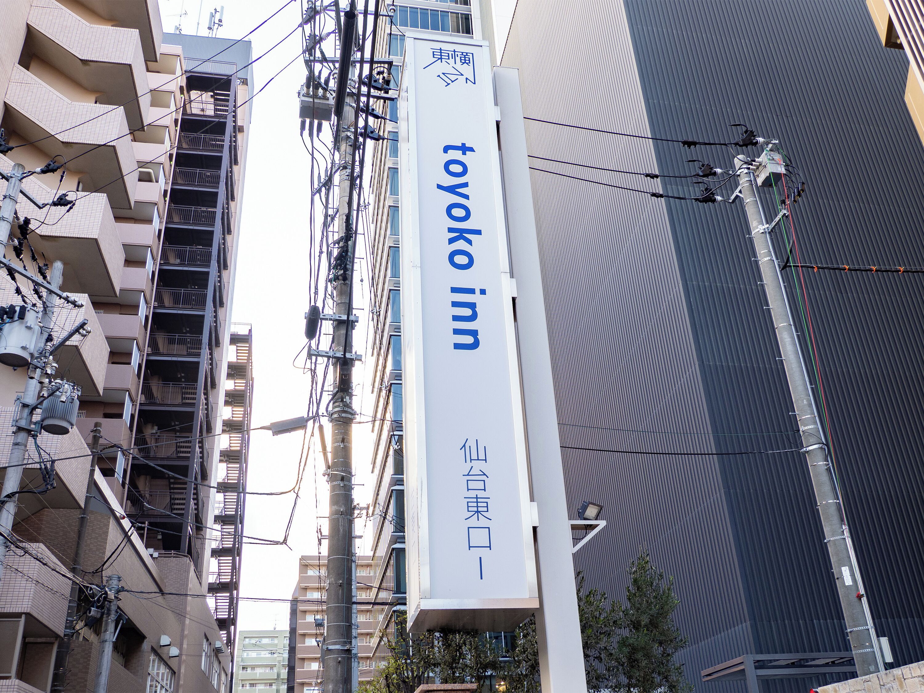 A tall building with a prominent sign for 'Toyoko Inn' in both English and Japanese.