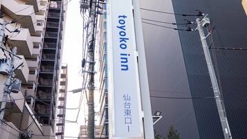 A tall building with a prominent sign for 'Toyoko Inn' in both English and Japanese.