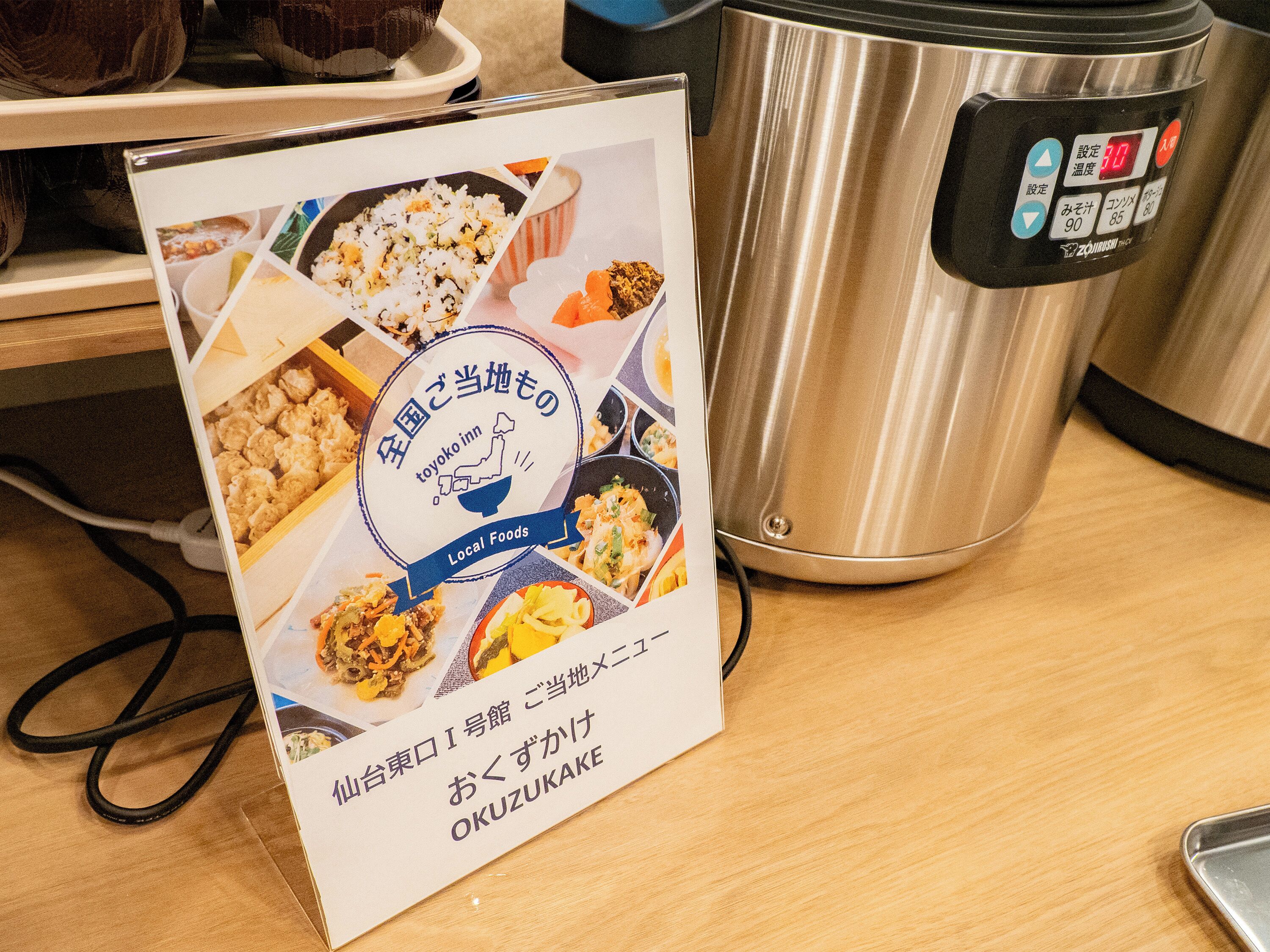A brochure with food images and a portable rice cooker on a table.