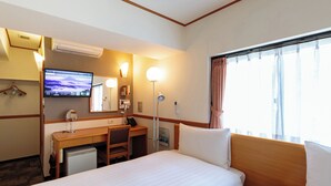 A hotel room with two beds, a desk, a chair, a TV, a mirror, and a window with curtains.