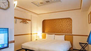 Une chambre d’hôtel avec un lit, une table de chevet, une lampe et une horloge au mur.