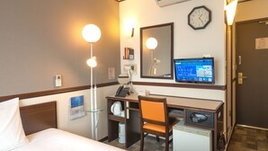 Habitación de hotel con cama, escritorio, silla y televisor mostrando un mensaje.