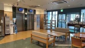 A modern lobby with a seating area, an elevator, a water dispenser, and a reception desk. - Toyoko Inn Hakata Ekimae Gion (Fukuoka)