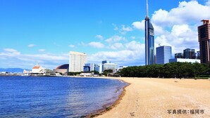A coastal cityscape with a prominent skyscraper, a beach, and various buildings. - Toyoko Inn Hakata Ekimae Gion (Fukuoka)