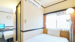 A hotel room with a bed, a desk with a computer, an air conditioning unit, a clock, and a window with curtains. - Toyoko Inn Nagoya Station Sakuradori Honkan (Nagoya)