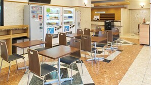 A cafeteria with multiple tables and chairs, vending machines, and a coffee machine. - Toyoko Inn Nagoya Station Sakuradori Honkan (Nagoya)