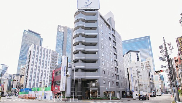 A modern hotel with a prominent sign in a foreign language, surrounded by high-rise buildings in an urban setting. - Toyoko Inn Nagoya Station Sakuradori Honkan (Nagoya)