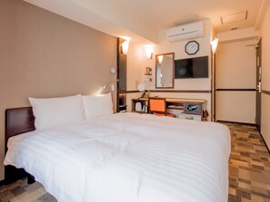A hotel room with a large bed, a desk with a computer, a mirror, a clock, and an air conditioning unit. - Toyoko Inn Sendai Higashi 2 (Sendai)