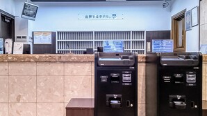 A reception area with a counter, a digital display, and two self-service kiosks. - Toyoko Inn Sendai Higashi 2 (Sendai)