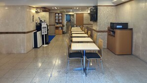 A clean, well-lit restaurant with a long counter, multiple tables, and chairs. - Toyoko Inn Tokyo Otsuka-eki Kita-guchi No.1 (Tokyo)