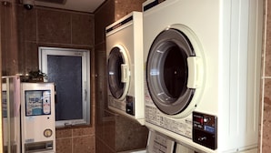 A laundry facility with two front-loading washing machines and a self-service dryer. - Toyoko Inn Kyoto Shijo-omiya (Kyoto)