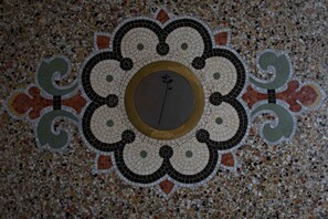 A detailed mosaic floor with a central circular design surrounded by intricate patterns. - Eclosion Château Hôtel & Restaurant (Saint-Paul en Jarez)