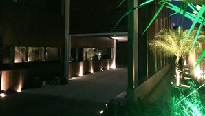 A modern building with a covered outdoor area, including a pathway and a small palm tree. - Zaya Motel Premium - Adults Only (Florianópolis)
