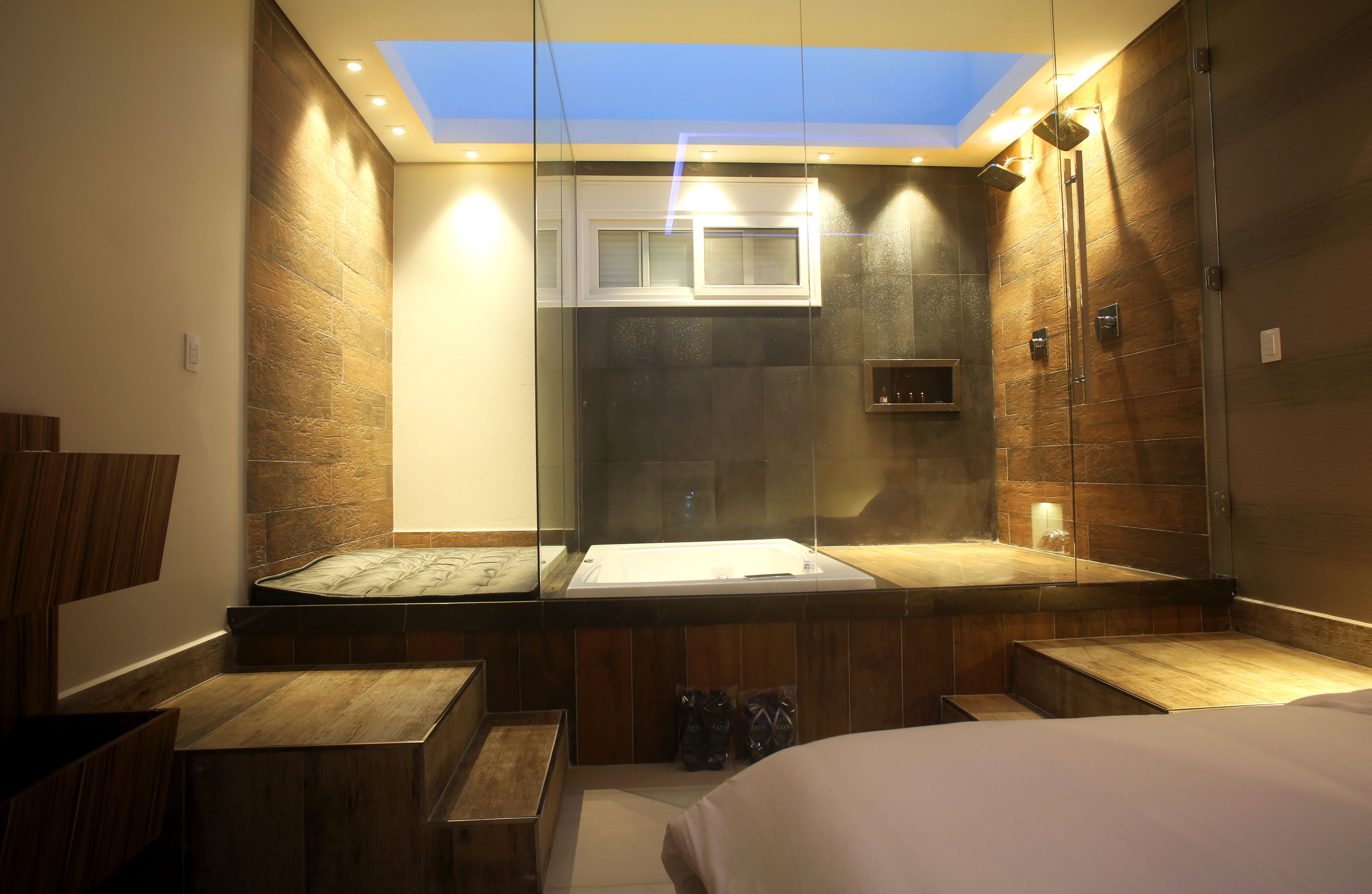 Un baño moderno con tragaluz, ducha integrada y tocador con espejo.