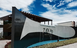 A modern building with a unique wave-like structure and the name 'ZAYO' prominently displayed. - Zaya Motel Premium - Adults Only (Florianópolis)