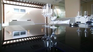 A hotel room with a glass table displaying empty wine glasses, a modern interior, and a view of the outdoors. - Zaya Motel Premium - Adults Only (Florianópolis)