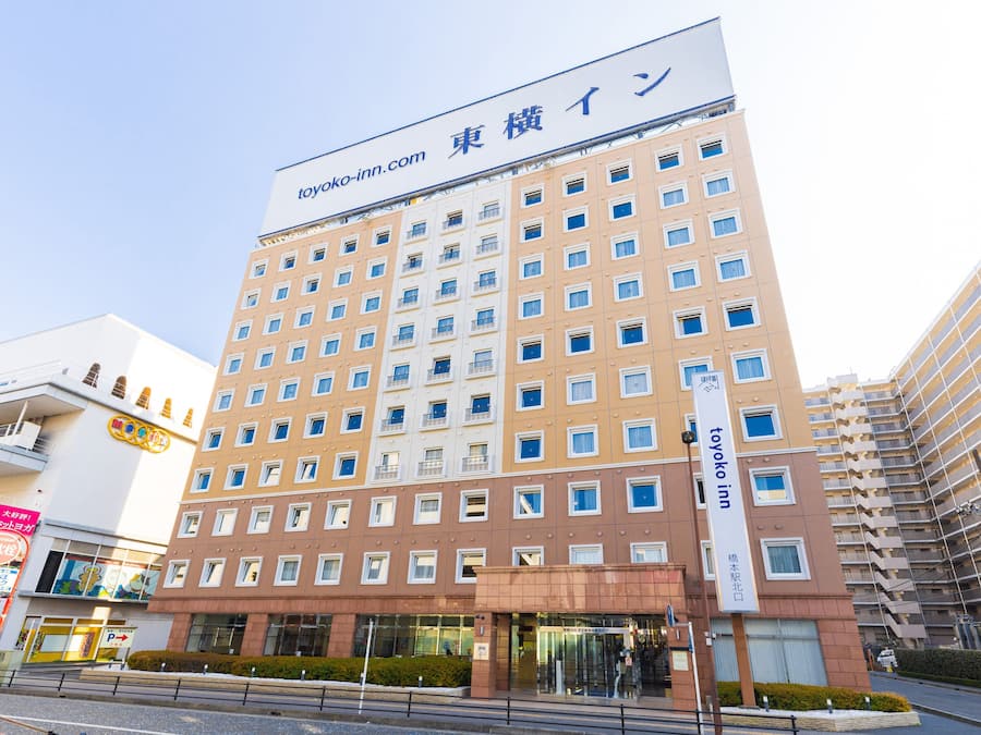 Een meerhoog hotel met een bord waarop 'toyoko-inn.com' staat.