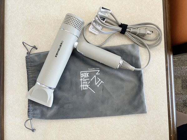 Un microphone et des câbles posés sur un tissu gris, avec du texte en japonais.