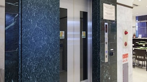 A modern elevator with marble walls and a digital display. - Toyoko Inn Chiba Station Higashi (Chiba)