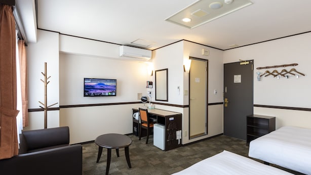 A hotel room with two beds, a desk with a chair, a TV, and a coat rack. - Toyoko Inn Ise Matsusaka Ekimae (Matsusaka)