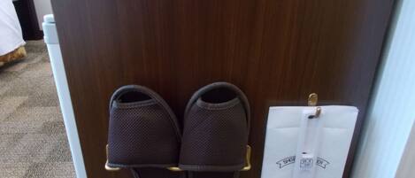 Un par de zapatillas en un zapatero y un mensaje en la puerta.