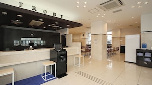 A modern hotel reception area with a 'FRONT' sign, a reception desk, seating area, and a self-service kiosk. - Toyoko Inn Ise Matsusaka Ekimae (Matsusaka)
