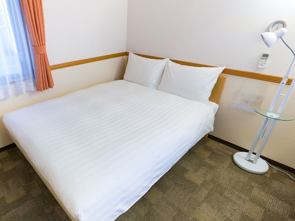 A neatly made bed with white linens in a hotel room. - Toyoko Inn Gumma Ota Station Minami (Ota)
