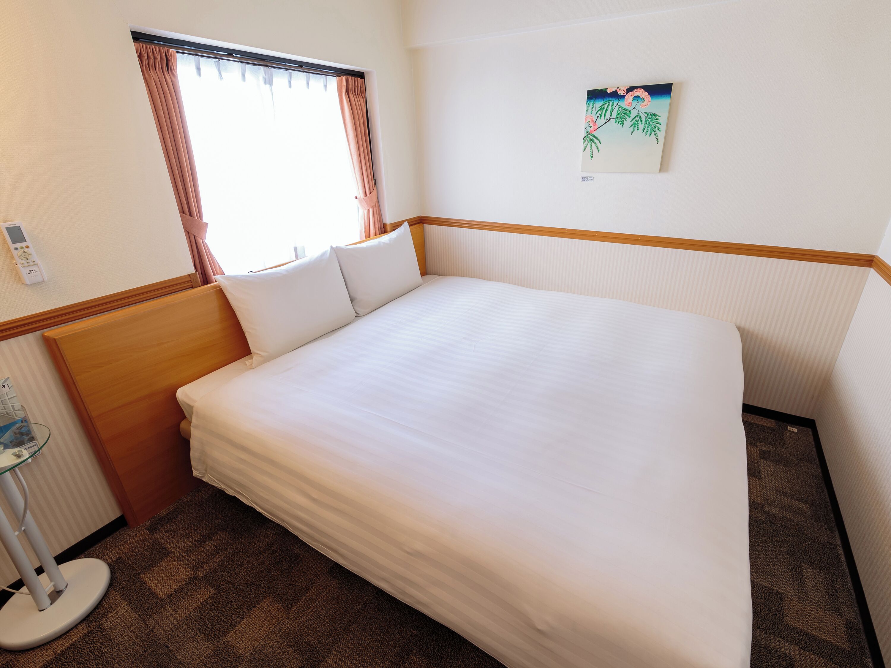 Una cama bien hecha con sábanas blancas en una habitación de hotel.