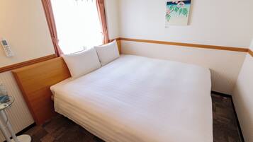 Una cama bien hecha con sábanas blancas en una habitación de hotel.
